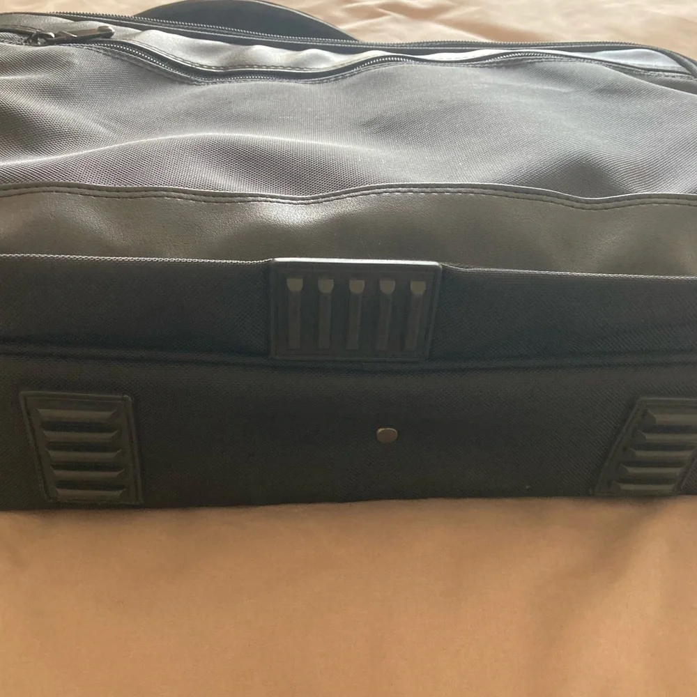 Gently used laptop bag in black nylon with several compartments.